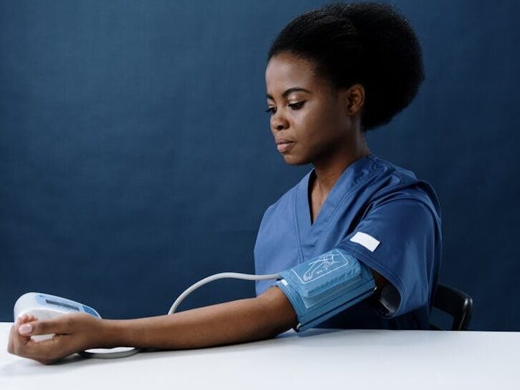 A Healthcare Worker Measuring Her Own Blood Pressure Using a Sphygmomanometer